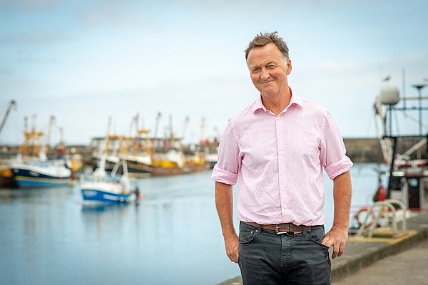 Andrew George in front of Newlyn harbour